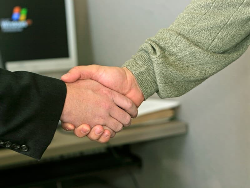 Professional business handshake representing compliance services - JLC Capital Group compliance solutions